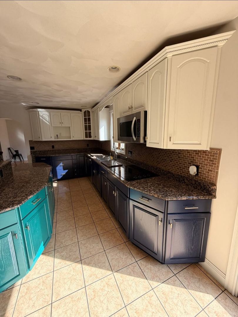 Kitchen Cabinet Painting – After 1 Kitchen with white painted upper cabinets, navy lower cabinets, and a teal island after cabinet painting