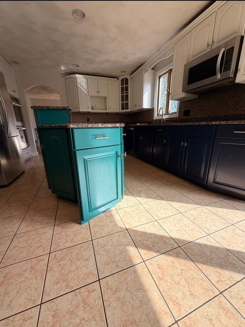 Kitchen Cabinet Painting – After 2 Teal painted kitchen island and navy base cabinets with white uppers after cabinet refinishing